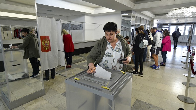 Des habitants des régions de Lougansk et de Donetsk qui vivent en Crimée, obtiennent leurs bulletins de vote lors d'un référendum à Sébastopol, en Crimée, le vendredi 23 septembre 2022.