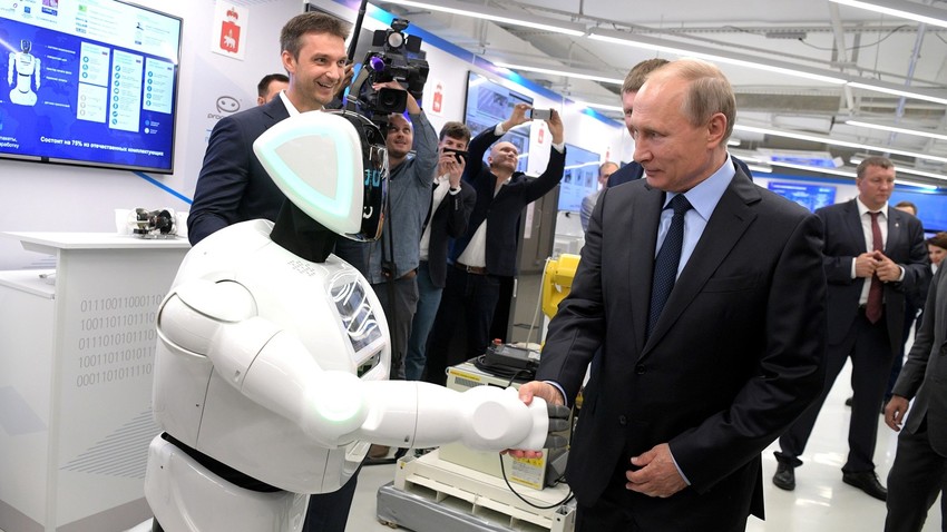 Putin menjabat tangan Promobot yang menyapanya.