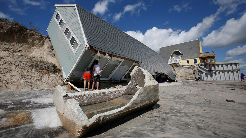 Local residents look inside a collapsed coastal house after Hurricane Irma passed the area in Vilano Beach, Florida, U.S., September 12, 2017. 