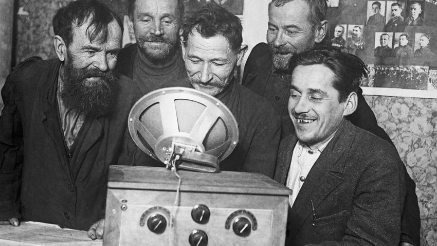 Einfache Bauern lauschen in ihrer Kolchose dem ersten Radiokonzert in der Sowjetunion.