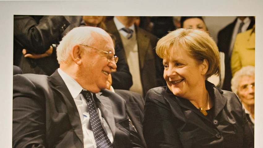 Der ehemalige sowjetische Präsident Michail Gorbatschow und die deutsche Bundeskanzlerin Angela Merkel unterhalten sich unter einem großen Fotodruck im Kennedy-Museum am Pariser Platz in Berlin im Februar 2011.