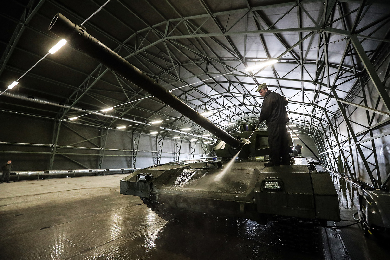 Seorang petugas membersihkan tank T-14 Armata di Moskow.