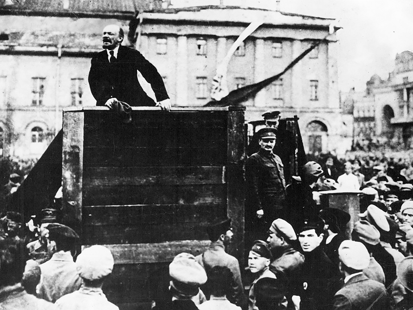 Vladimir Lenin addresses crowd In Petrograd's Sverdlov Square in 1919. Leon Trotsky stands on the right.