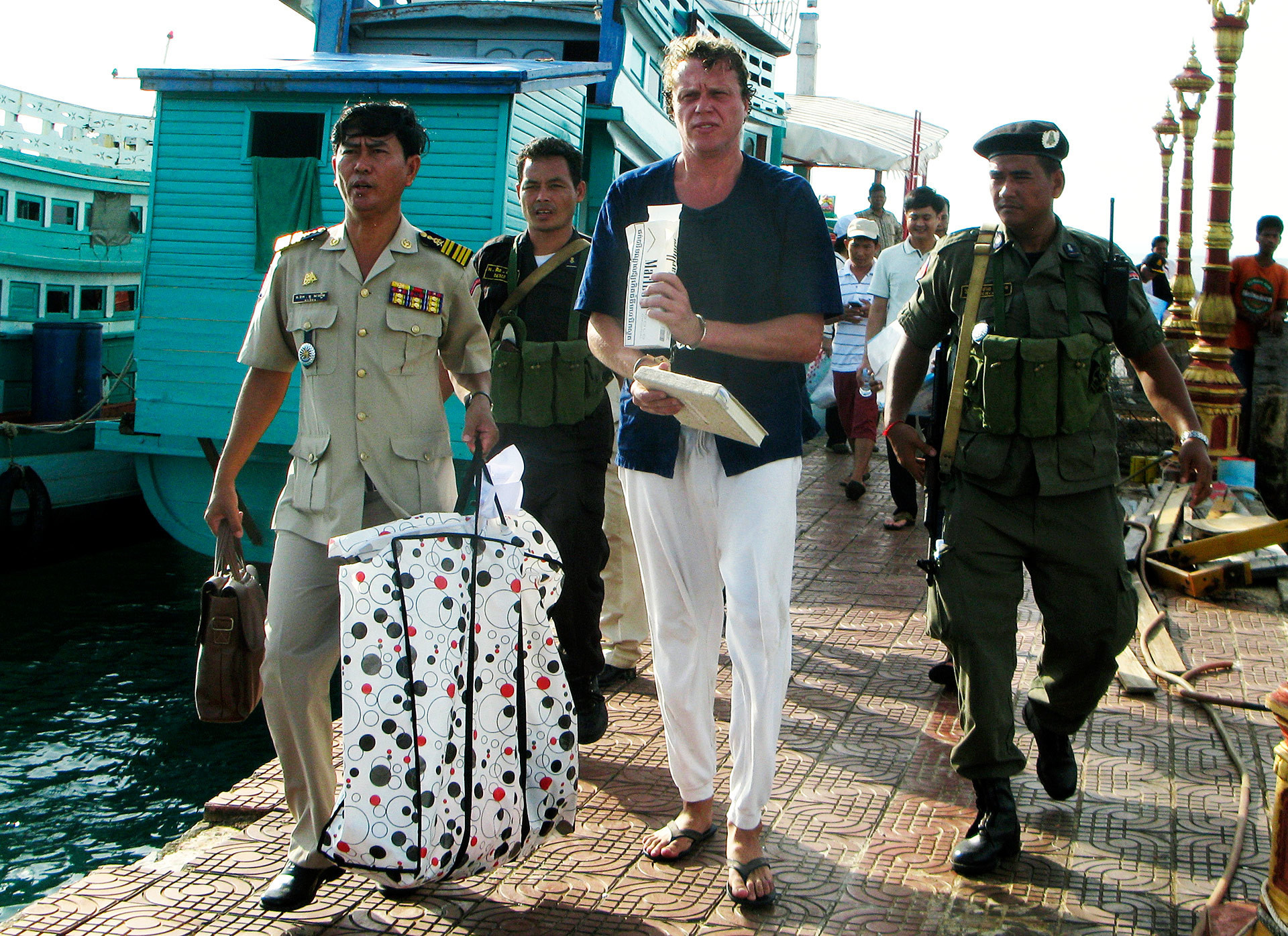 Polonski escoltado por policiais no Camboja