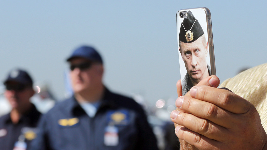 Obiskovalec fotografira letalo s telefonom, na katerem je portret Vladimirja Putina.