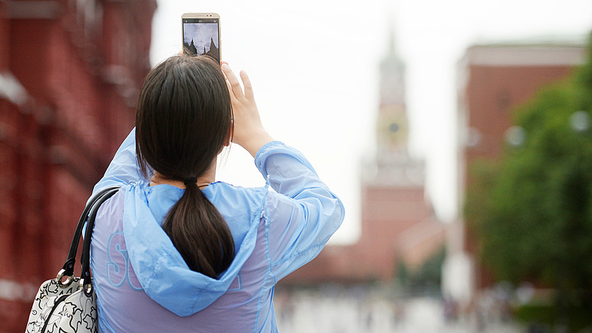 A tourist takes pictures of Kremlin in Moscow. 