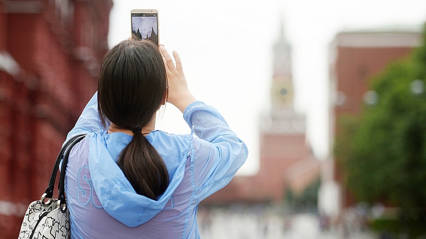 Turistka v Moskvi fotografira Kremelj
