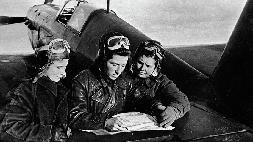 Female pilots of the 586th regiment: Litvyak, Budanova and Kuznetsova (left to right) near the YaK-1 aircraft.