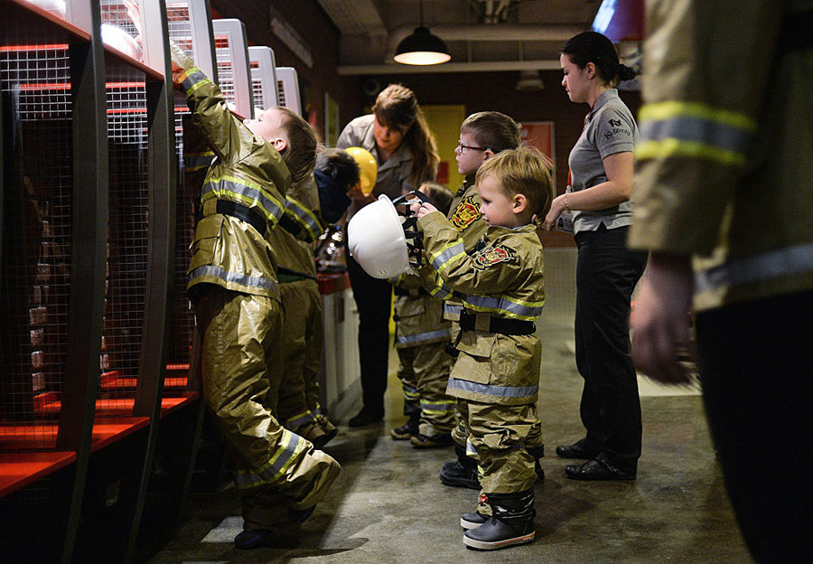 Children learning fire-extinguishing skills at the fireman area of the Kidzania game training park in Moscow