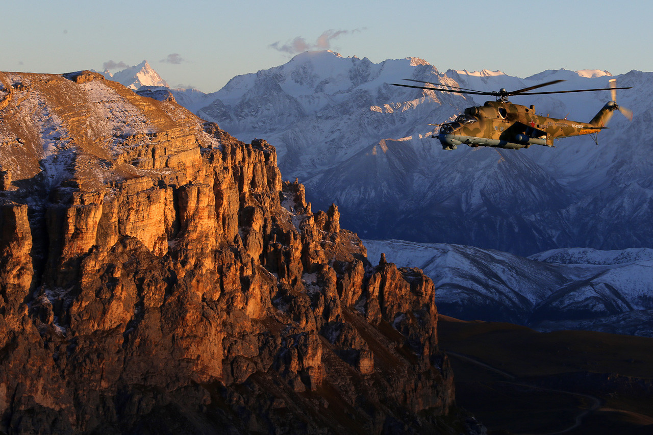 The Mi-24 helicopter, flying in the Caucasus at twilight.