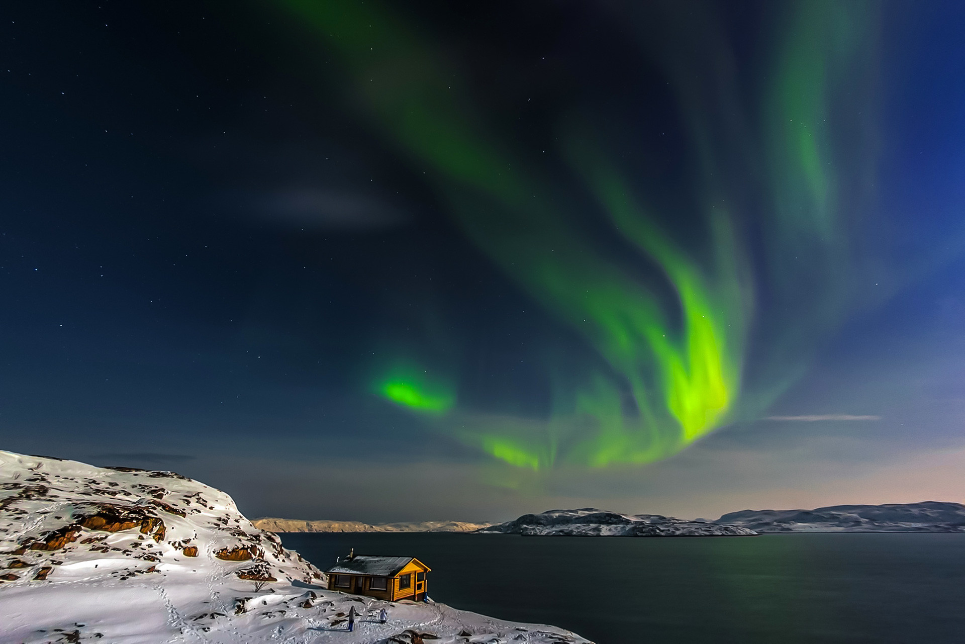 A cozy house on the coast of the Barents Sea and the aurora. Kola Peninsula, Murmansk region.