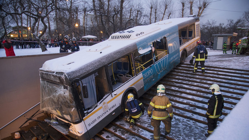 Petugas unit darurat berupaya menarik bus yang terperosok ke tangga utama menuju kereta bawah tanah Moskow, Senin (25/12).