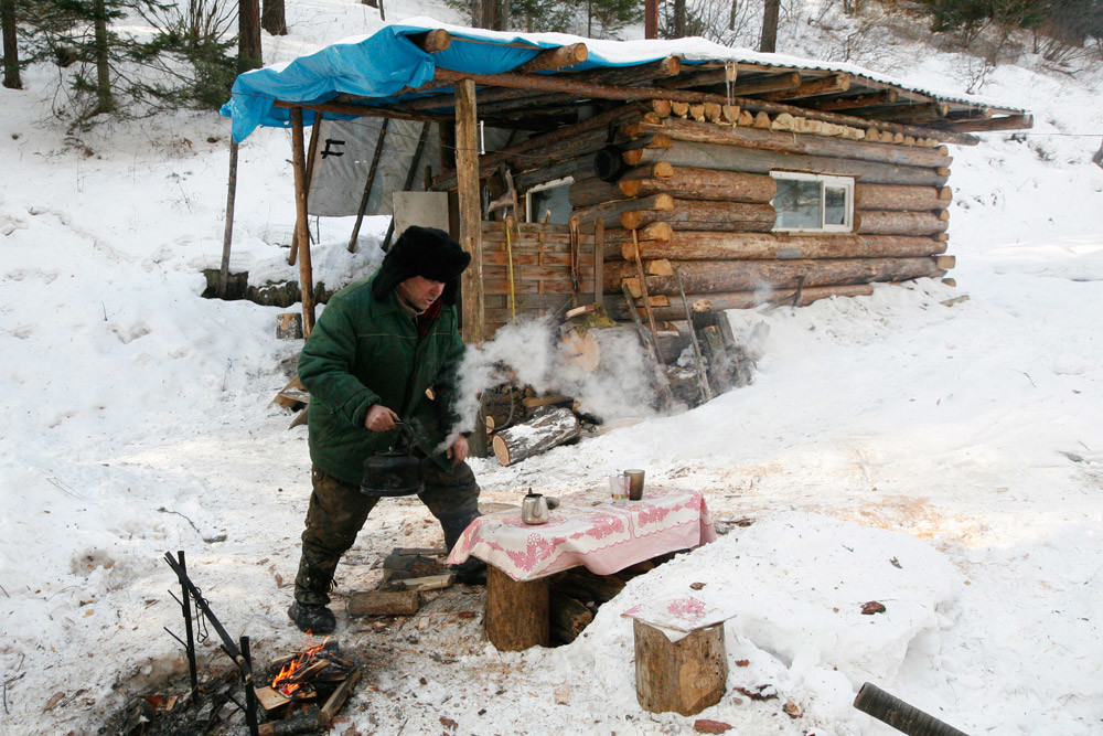 Јушков подготвува чај по возењето кон ловечката куќа покрај реката, која сам ја изградил во далечно подрачје на тајгата. 