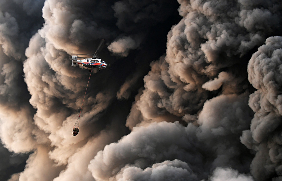 A Russian emergency service helicopter carries water past billows of smoke as firefighters battle a blaze in a shopping mall on Moscow’s western outskirts.
