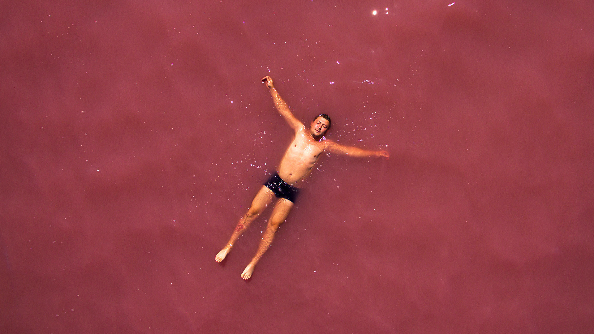 Човек се излежува на соленото Малиново езеро во Алтајскиот крај.