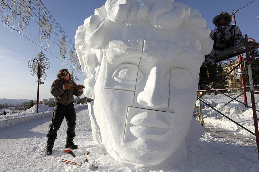 Anggota tim dari kota Perm, Rusia, mengerjakan patung salju dalam Festival Internasional Patung Salju dan Es Pertama “Keajaiban Es Siberia” di Krasnoyarsk.