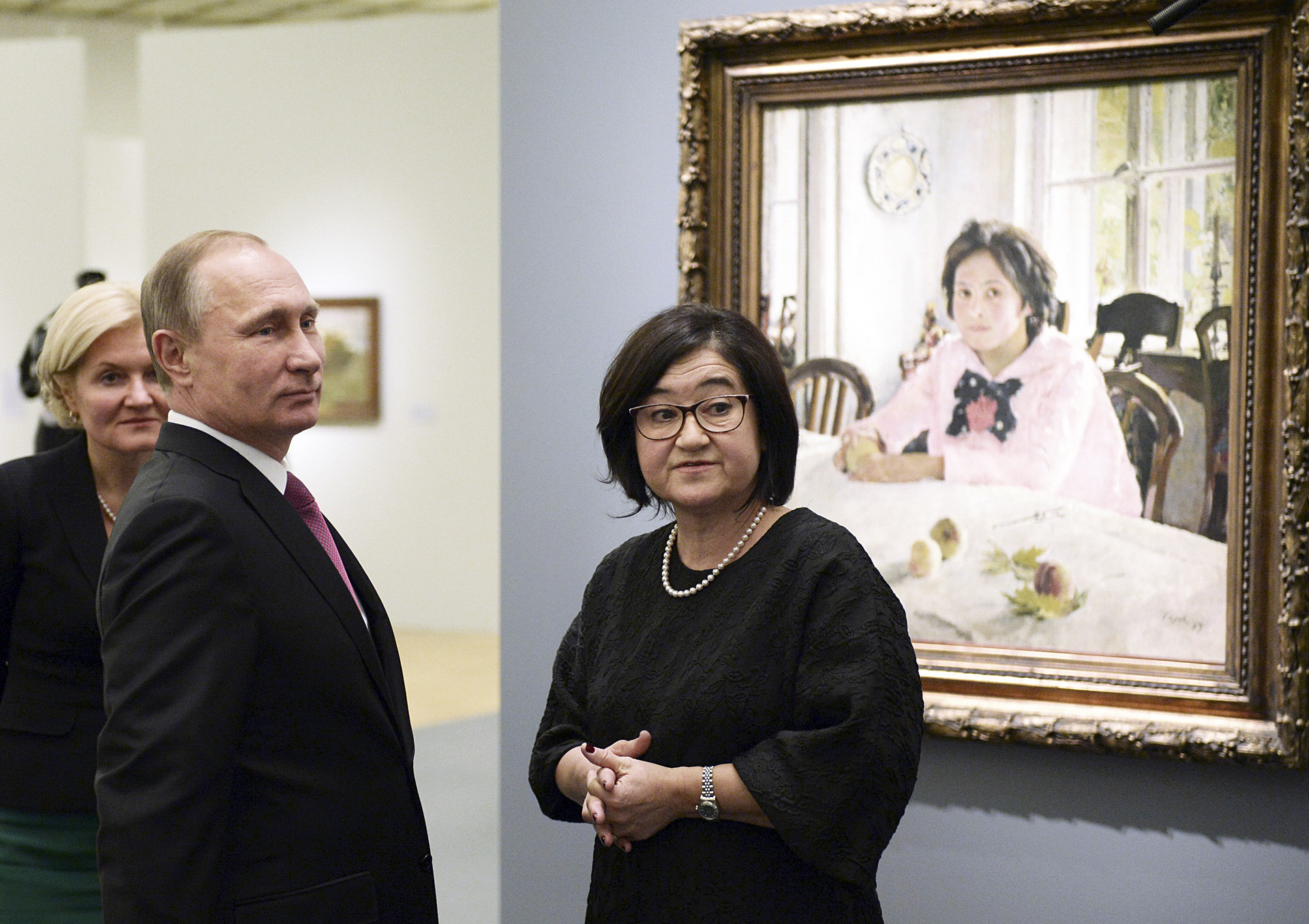 Vladimir Putin mendengarkan Direktur Galeri Nasional Tretyakov Zelfira Tregulova saat ia mengunjungi pameran seniman Valentin Serov.