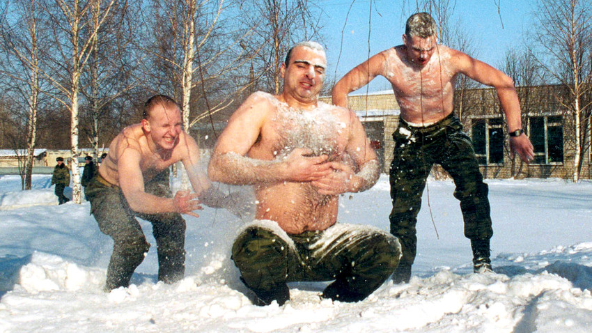 Servicemen of Russian army unit #2050 rub themselves with snow.
