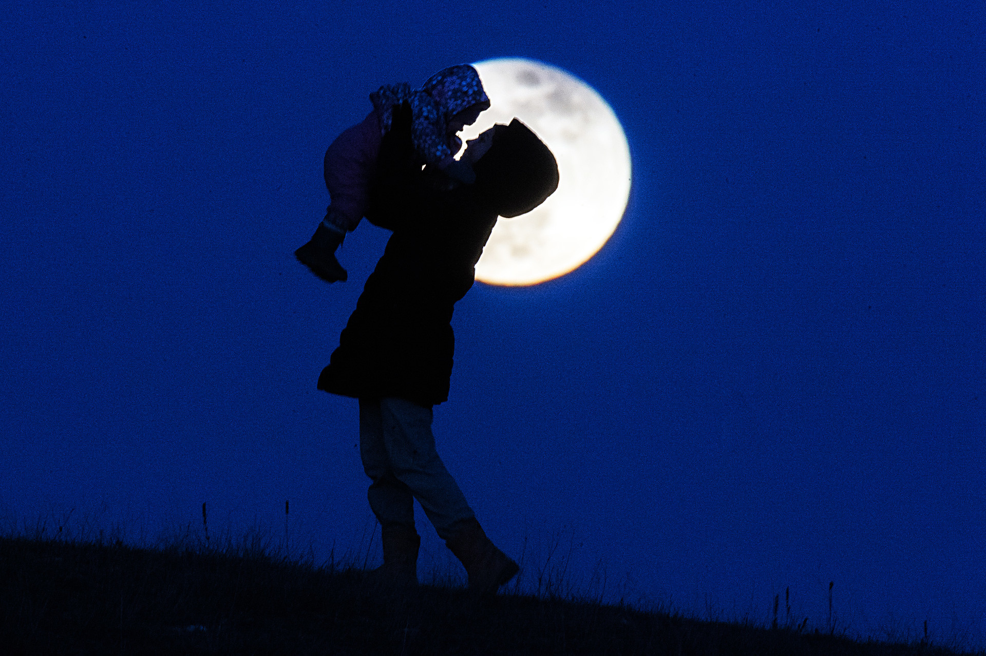 Seorang ibu membawa anaknya berjalan-jalan malam hari di kota Simferopol.