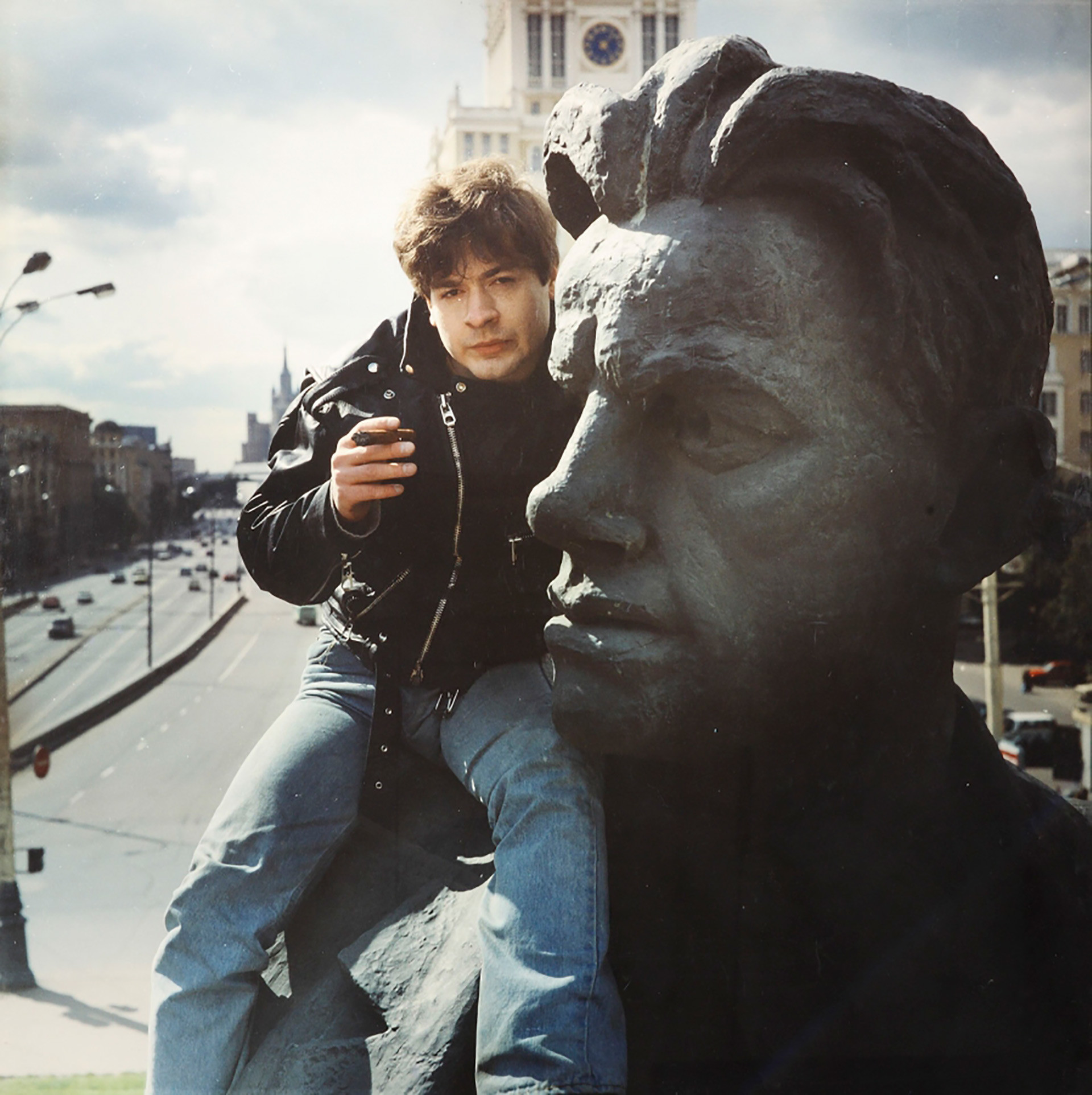 Anatolij Osmolovskij seduto sul monumento del poeta Vladimir Majakovsksij a Mosca, durante la performance “Journey of Necesiudik in the land of Brobdingnegs”, del 1993