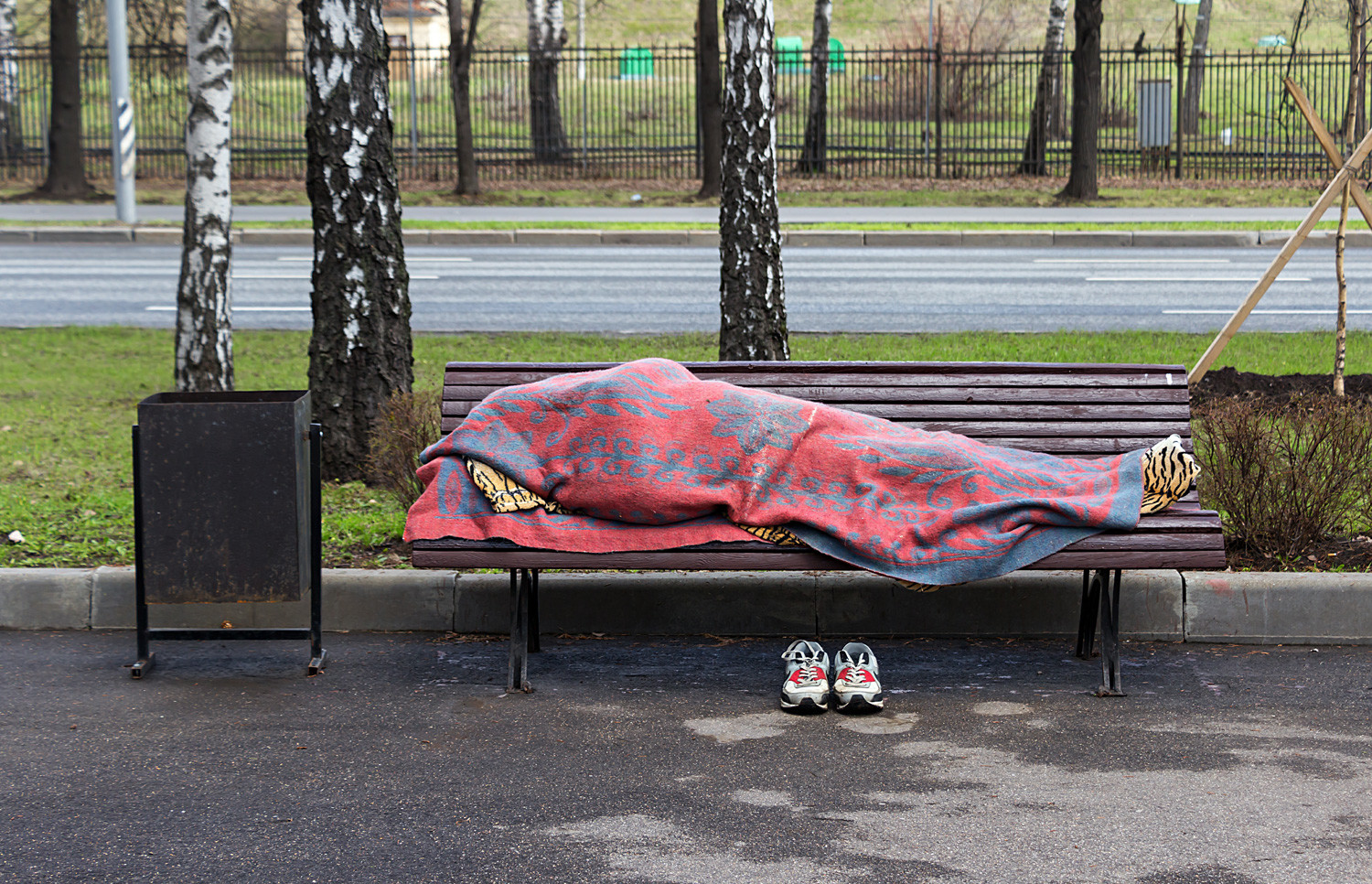 A homeless person sleeping on a bench near Sparrow Hills, Moscow.