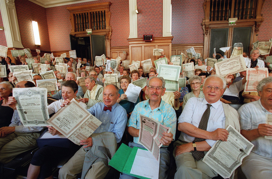 Jezni delničarji ruskih obveznic v rokah držijo svoja potrdila v pariški sodni dvorani, 26. junija 2001.