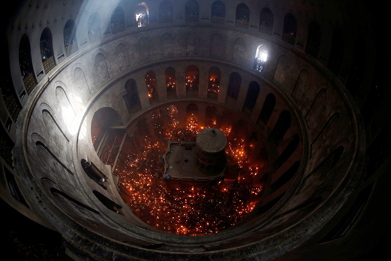 Jemaat memegang lilin dalam perayaan Api Suci Ortodoks di Gereja Makam Kudus, Yerusalem.