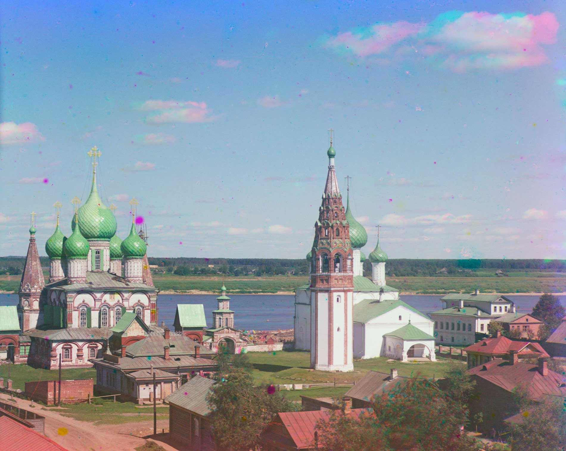 Korovniki ensemble: Church of St. John Chrysostome (left), Holy Gate, bell tower, Church of the Vladimir Icon. Northwest view. Background: Volga River. Mottled appearance of clouds caused by motion during three exposure color process. Summer 1911.
