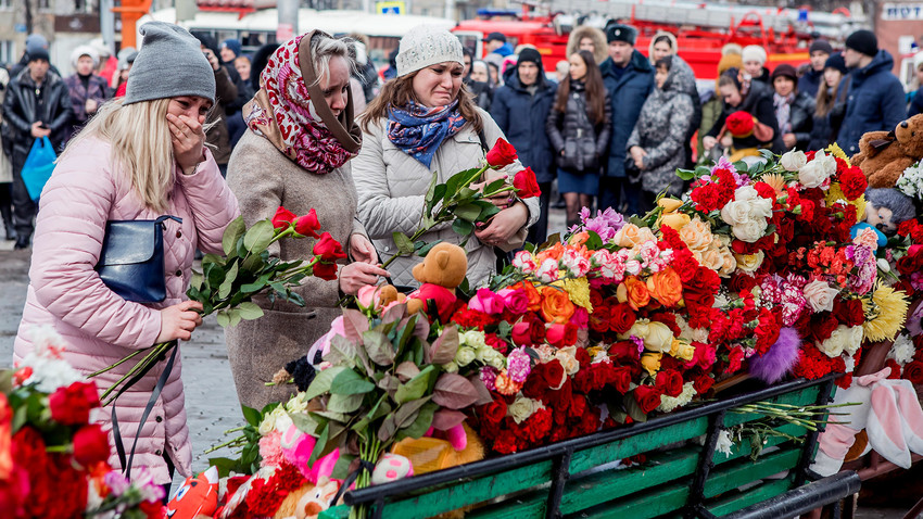 Pessoas depositam flores em homenagem às vítimas de incêndio em Kemerovo