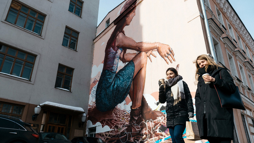 Two women passing Fintan Magee's 'Message'