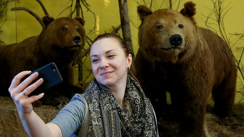A woman takes a selfie by stuffed brown bears at the Ryazan Kremlin Historical and Architectural Museum-Reserve as she takes part in Museum Selfie Day