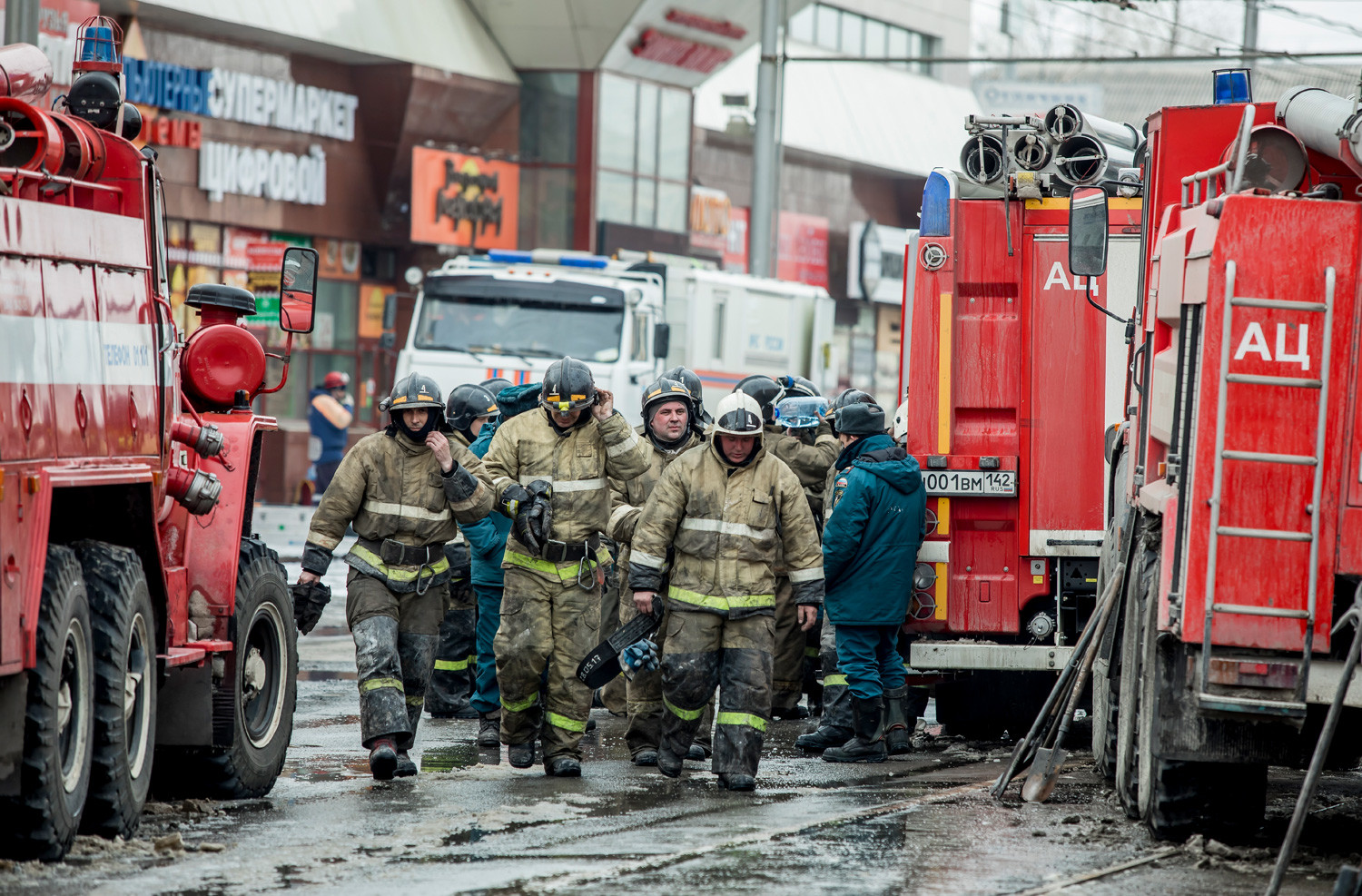 A group of firefighters walk near the scene of the shopping center after a fire on March 26, 2018.