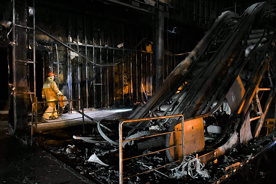 Oficiales del Ministerio de Emergencias de Rusia en el centro comercial “Zímniaia Víshnia”medio quemado.