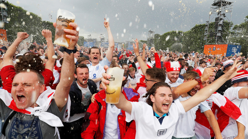 Hinchas ingleses celebran un gol mientras toman cerveza.