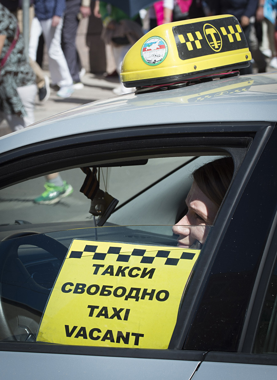 Taksist čaka na stranke v Sankt Peterburgu.