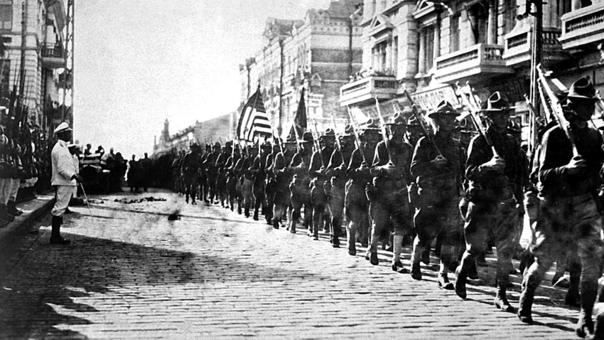 American troops in Vladivostok, parading. Japanese marines are standing to attention as they march by. August 2018.