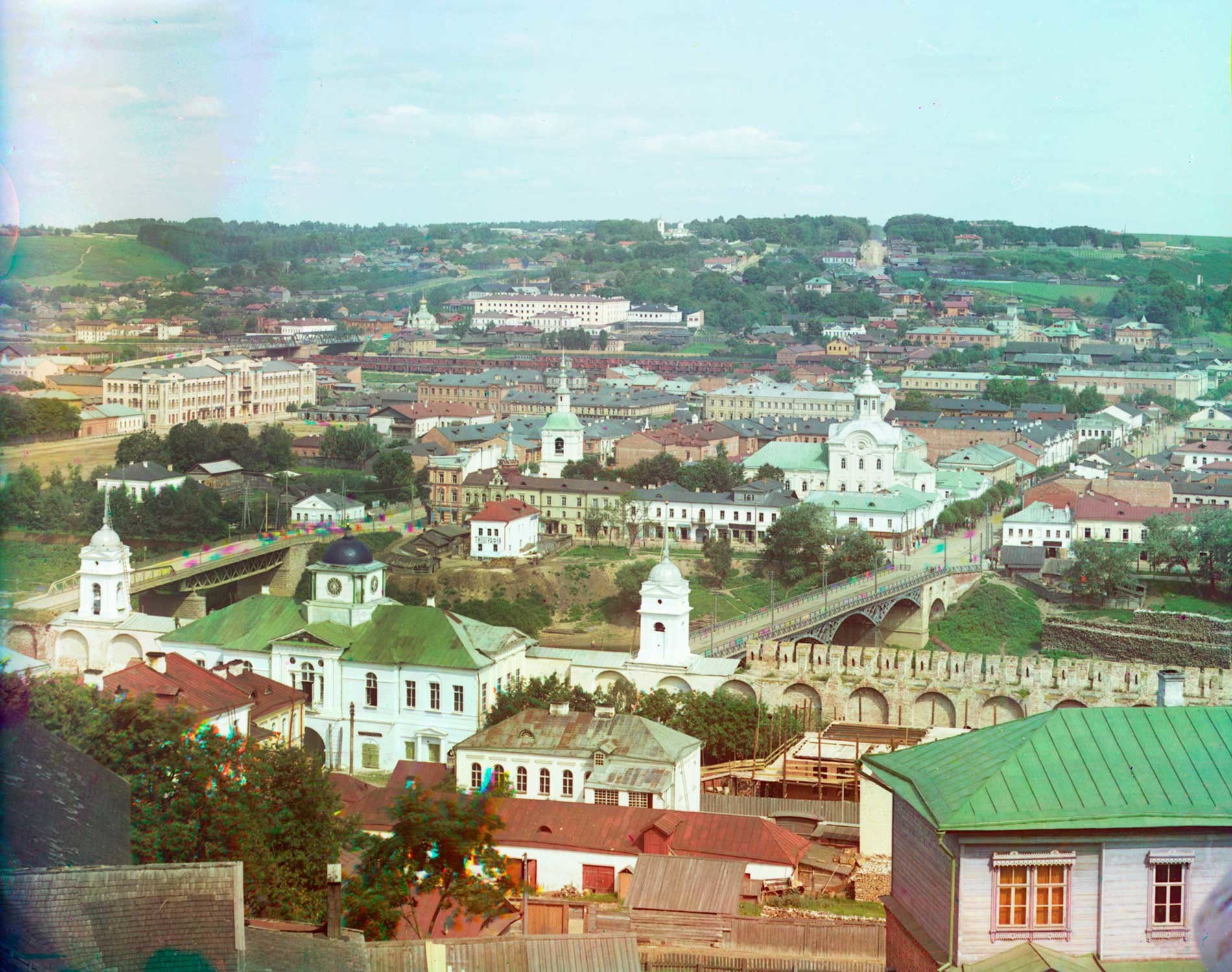 Smolensk. View north from Dormition Cathedral bell tower. North wall and Dnieper Gate with Gate Church of the Hodegetria Icon. Beyond the two bridges across the Dnieper River is the Church of St. Nicholas. Summer 1912