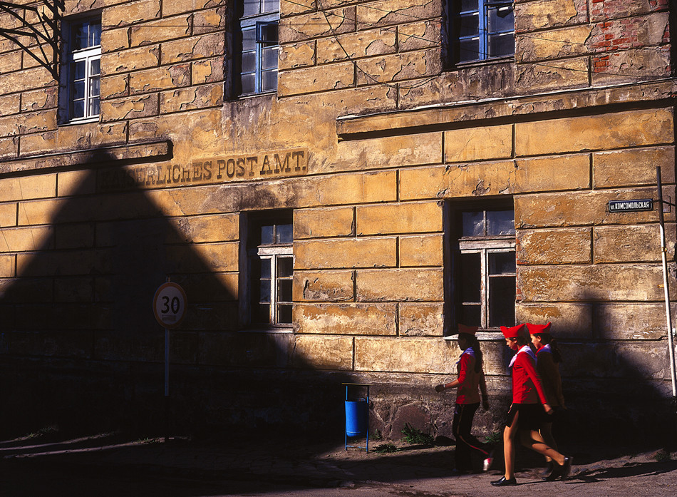 Unas pioneras junto a un edificio que todavía lleva la inscripción en alemán "Oficina de correo imperial", Ozersk