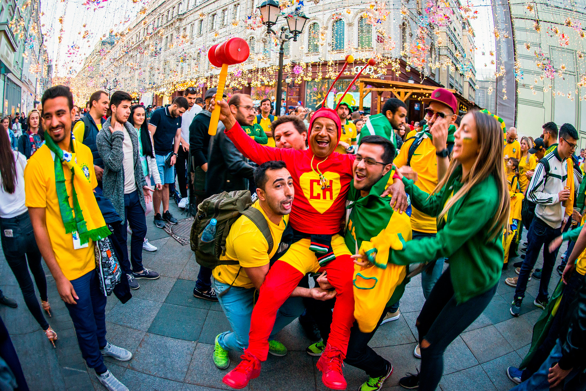 Brazil fans give a leg up to a Swiss supporter dressed as an insect – because why not!