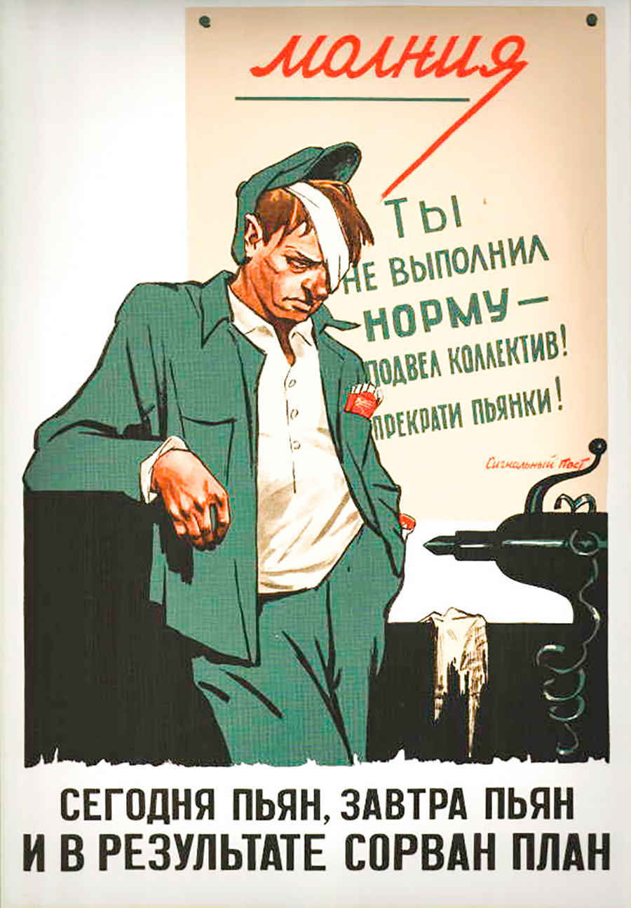 The poster behind his back says: ‘You didn’t fulfill the work norms – you’ve failed the team! Stop binges!’ The inscription below says: ‘Drunk today, drunk tomorrow – work plan is disrupted!’