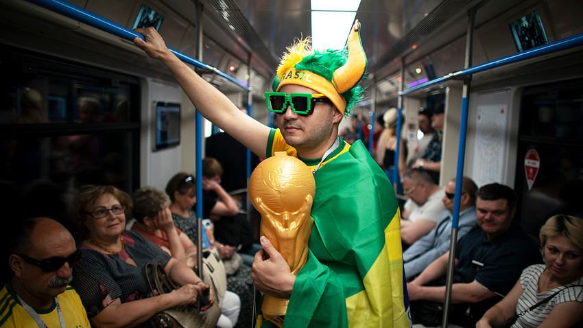 A fan wrapped in a Brazilian flag travels on the subway to Spartak Stadium.