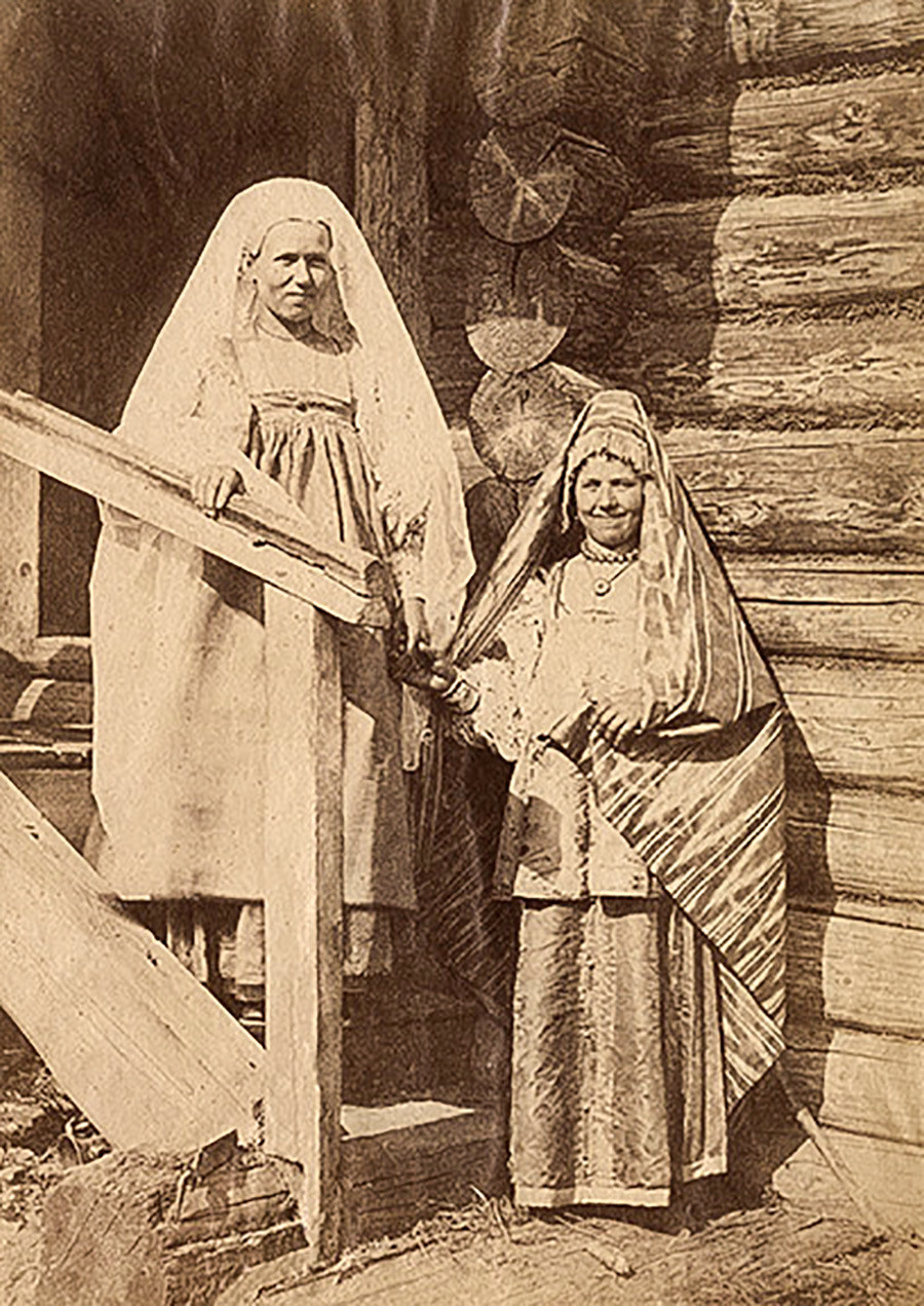 Seorang perempuan dan wanita bersuami dalam kostum perayaan.