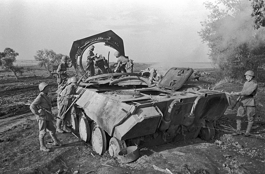 Soviet soldiers standing by a Nazi self-propelled gun Panther destroyed by the Soviet artillery in Prokhorovka. The Kursk Bulge.