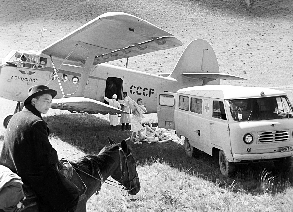 ソ連。An-2患者輸送機が薬品を山にある牧草地に郵送している
