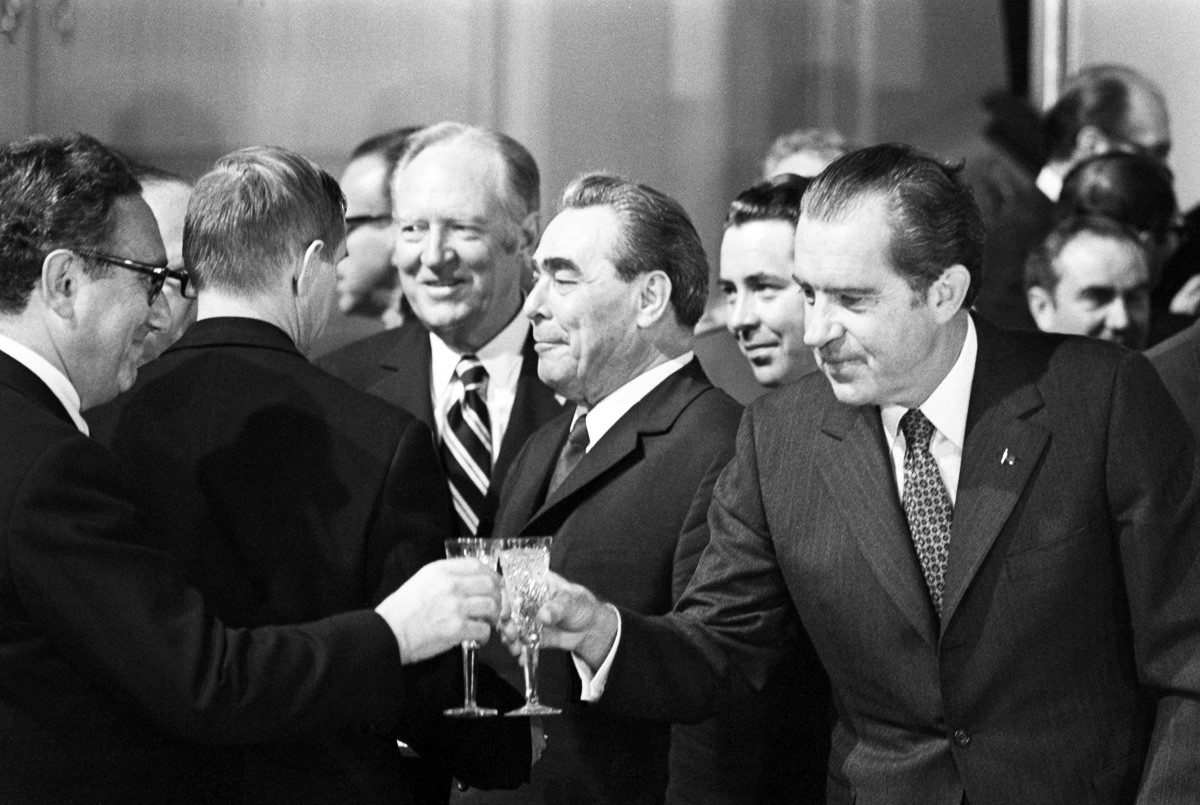 US President Nixon reaches to clink his glass with that of Henry Kissinger in Moscow in 1972 with USSR leader Leonid Brezhnev in the background