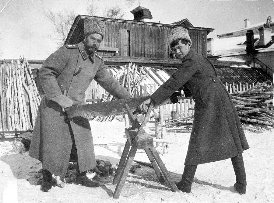 O tsarêvitch Aleksêi e o tsar Nikolai 2° serrando madeira em Tobolsk, em 1917 .