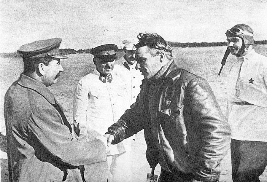 Stálin cumprimenta Tchkalov. Na foto também estão Vorotchilov, Kaganovitch e Beliakov