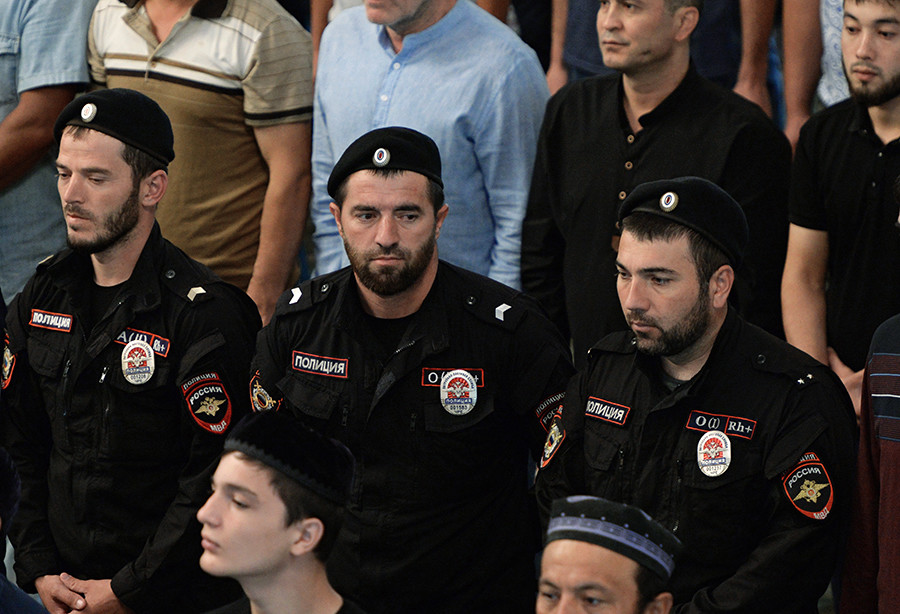 Tiga orang polisi tampak berada di antara jemaah yang hendak melaksanakan salat Id di Masjid Jantung Chechnya, Grozny, Republik Chechnya, Rusia.