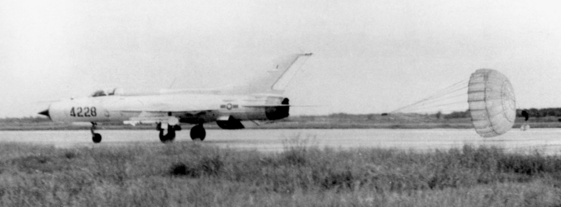 MiG-21 PF de la Fuerza aérea norvietnamita despliega su paracaídas de frenada al aterrizar tras realizar una misión. El avión está armado con misiles aire-aire AA-2 Atoll.