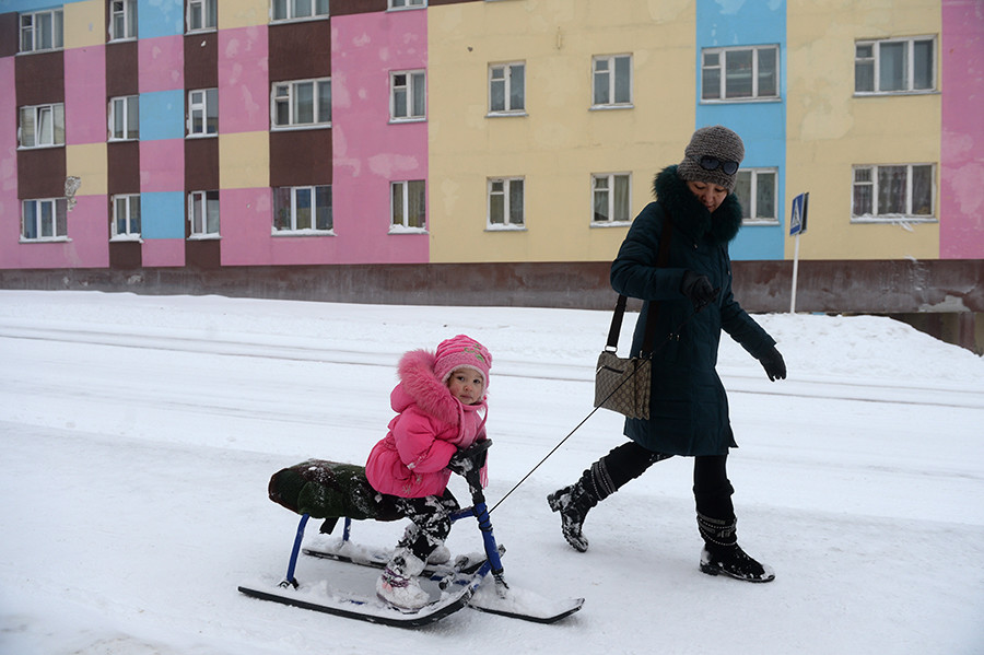 A woman with a child on a street in Anadyr. November 2013.